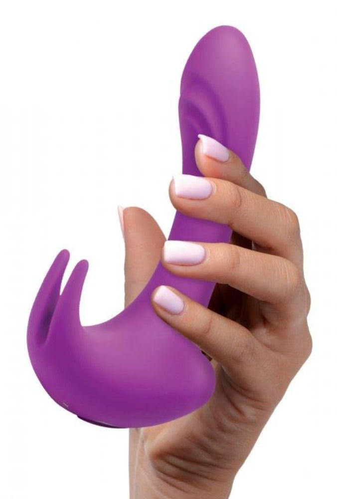 A purple G-spot rabbit vibrator held in a hand.