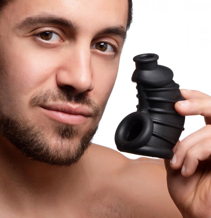 Flexible black silicone chastity cage with ribbed texture.