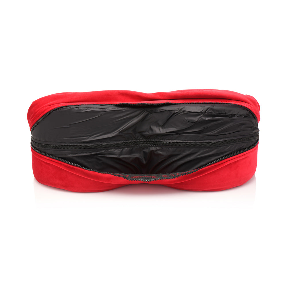 Red velvet heart-shaped positioning pillow with an open black zippered compartment.