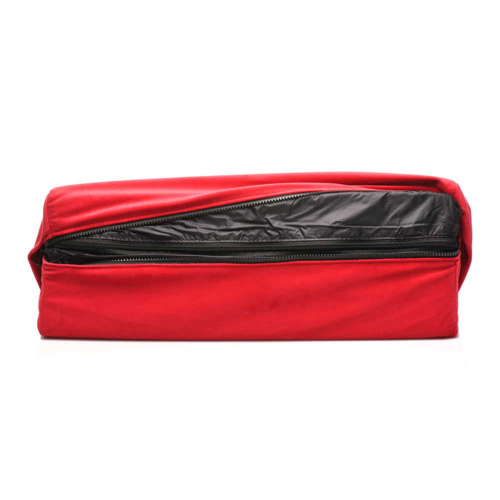 Red velvet wedge pillow with a black zippered opening.