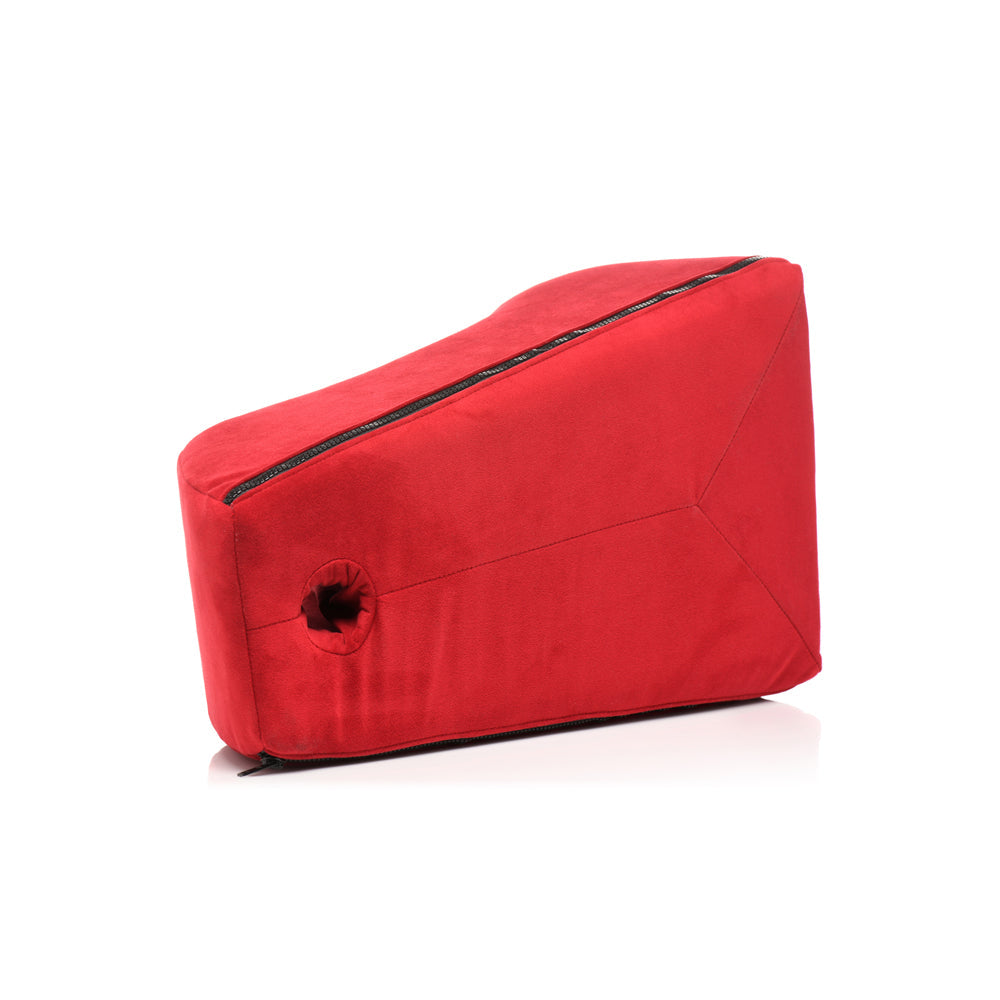 Red foam positioning pillow with a zippered top and a hole for a toy.