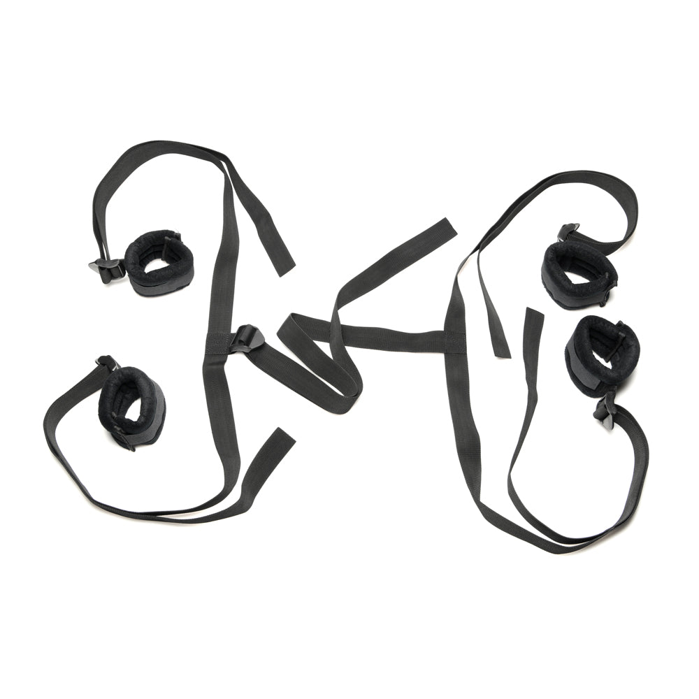 Black bed restraint system with padded cuffs and adjustable straps.