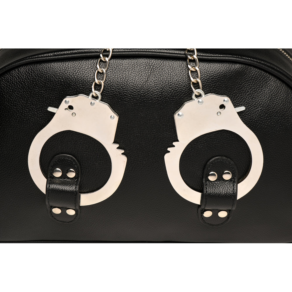 Black vegan leather travel bag with decorative handcuffs.