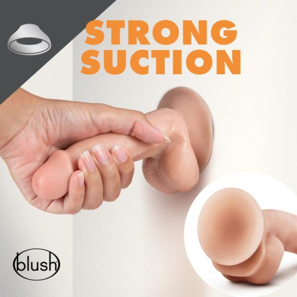 A hand holds a pink dildo with a suction cup base against a white surface.