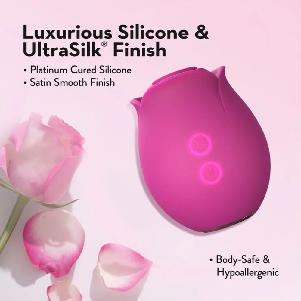A pink rose-shaped massager made of silicone with two illuminated buttons.