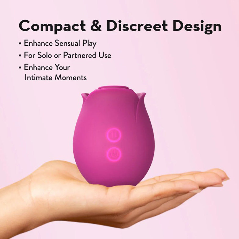 A pink rose-shaped massager with two illuminated buttons rests on an open palm.