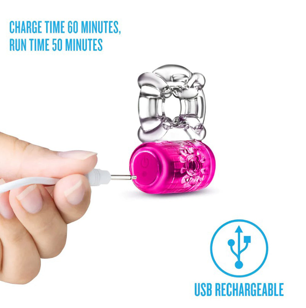 A pink vibrating C-ring with a clear attachment, being charged by a USB cable.