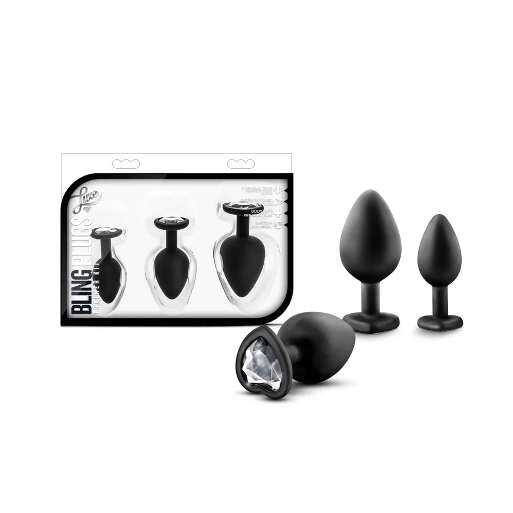 A silicone anal training kit with three black plugs, one with a white gem base.