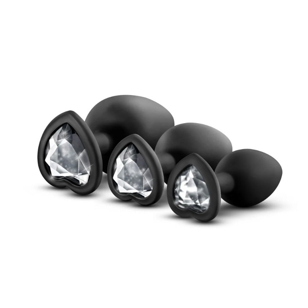 Black silicone anal plugs with heart-shaped white gem bases.