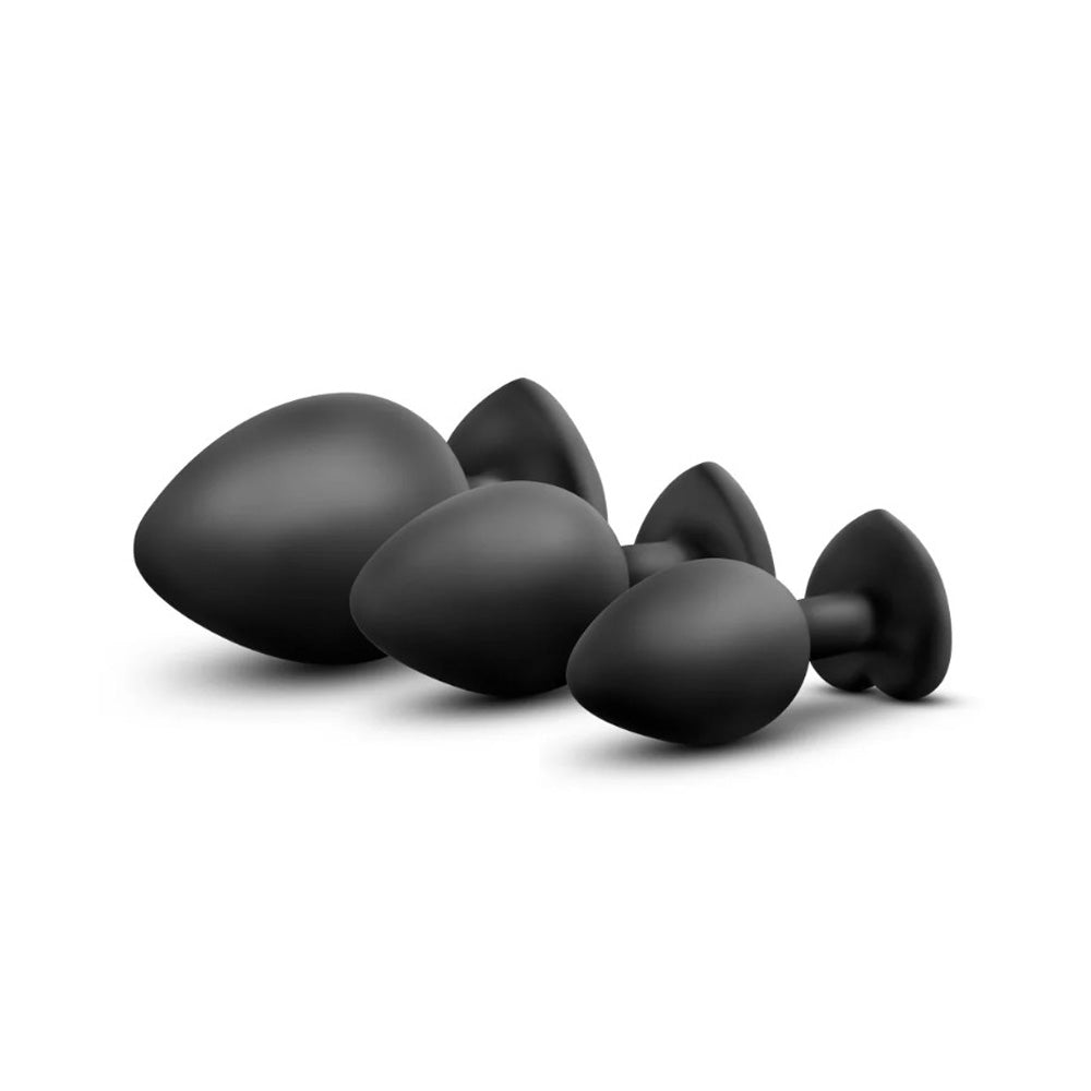 Four black silicone anal plugs of varying sizes.