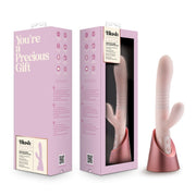 A pink Fraya thrusting rabbit vibrator with a charging stand.