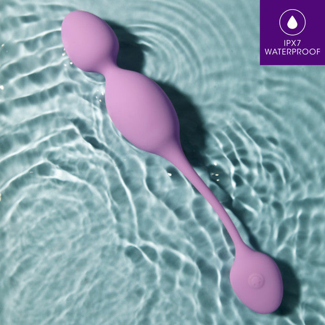 A purple vibrating kegel ball with a remote control rests in rippling water.