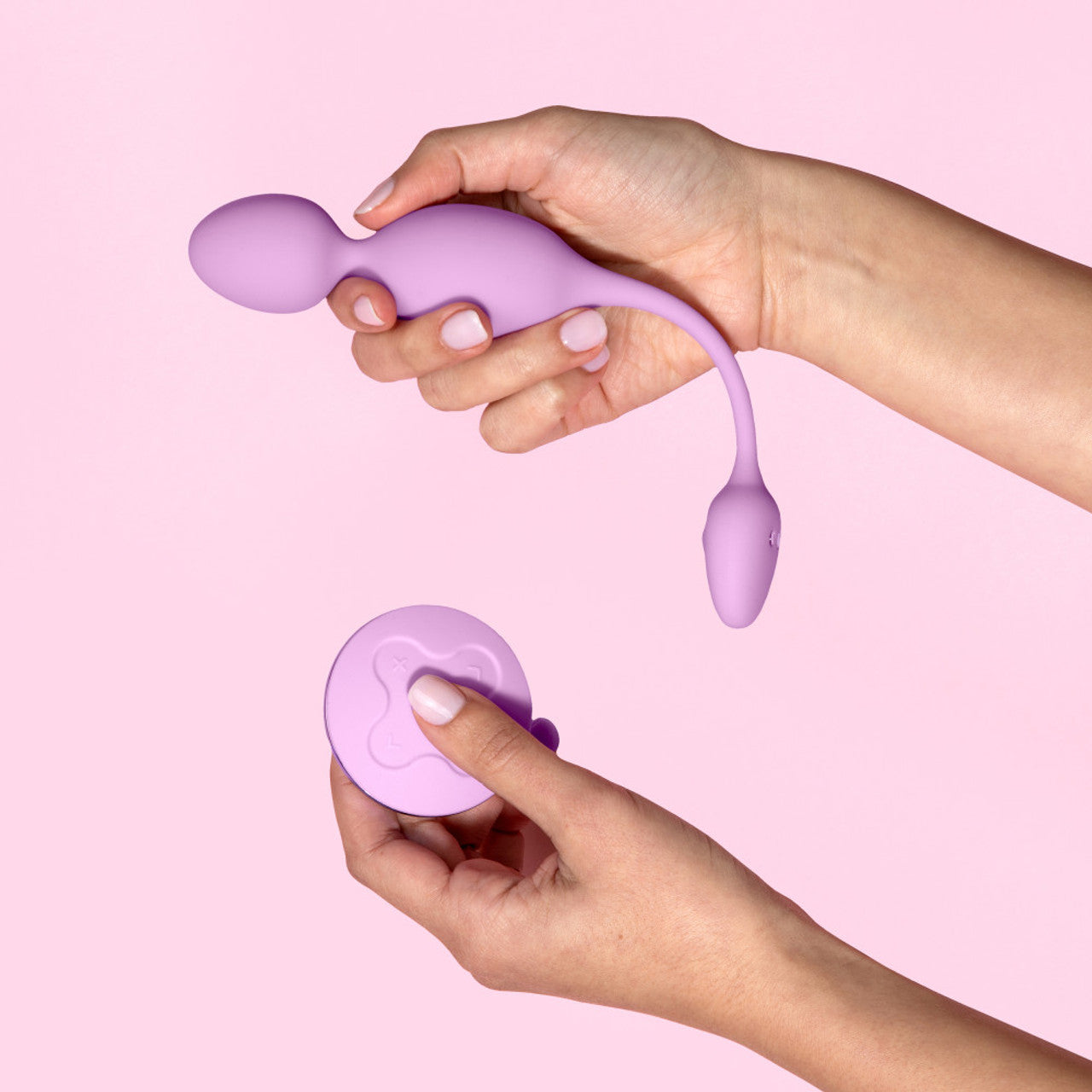 A purple vibrating kegel ball with a remote control held by two hands.