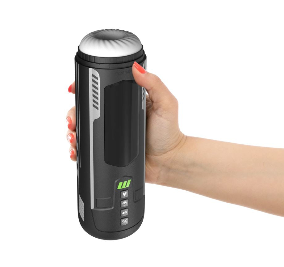 A hand holds a black automatic stroker with a white textured opening and green indicator lights.
