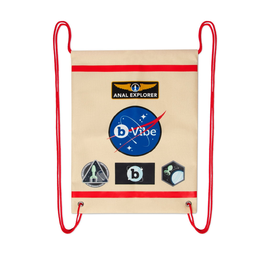 A beige drawstring bag with red trim and space-themed patches.