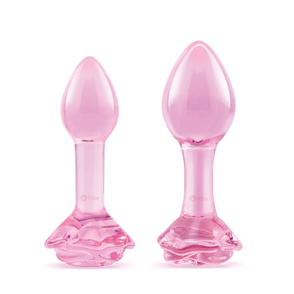 Two pink glass butt plugs with rose-shaped bases.