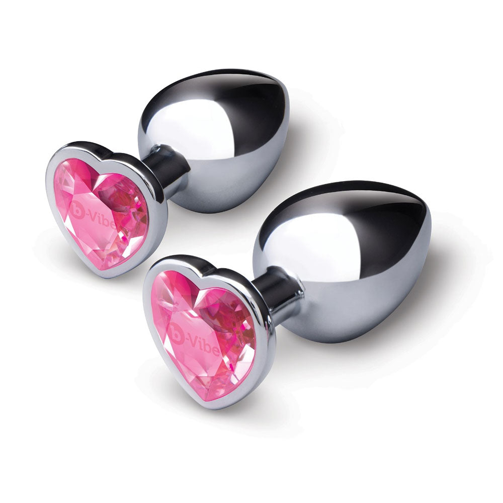 Two silver metal butt plugs with pink jewel heart bases.