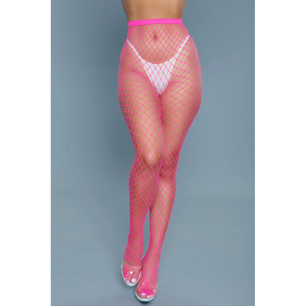 Hot pink oversized fishnet pantyhose with white underwear and clear heels.