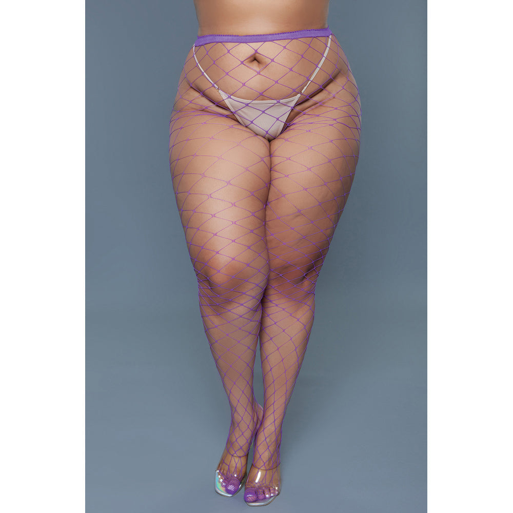 Purple oversized fishnet pantyhose with a thong and clear heels.
