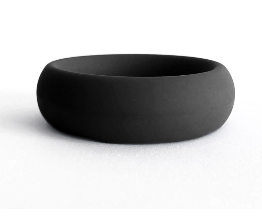 A thick, black silicone ring on a white surface.