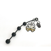 Black silicone anal bead chain with a skull charm and tag.