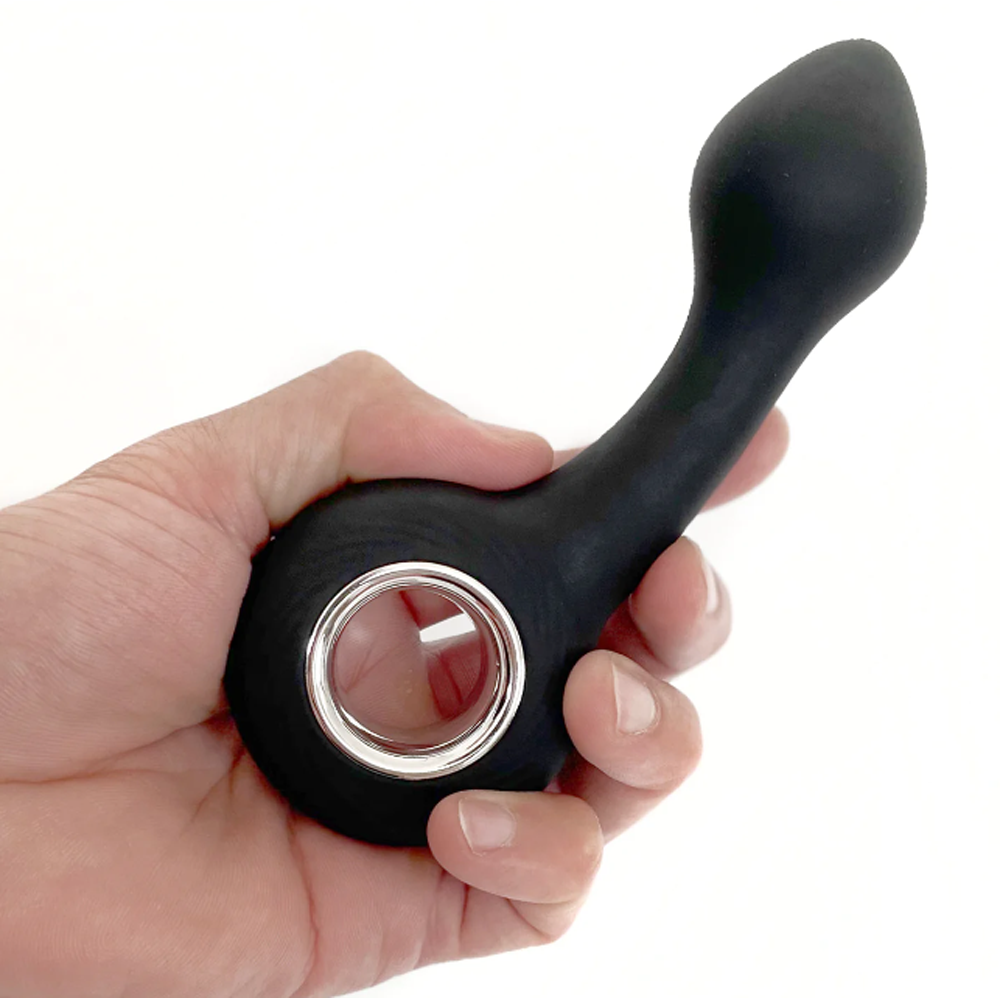 Black silicone G-spot vibrator with a silver ring held in a hand.