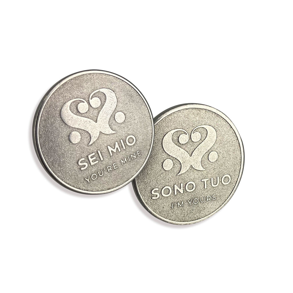 Two stainless steel coins with heart designs and Italian phrases.