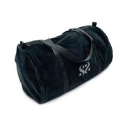 A dark velvet duffle bag with grey straps and a white logo.