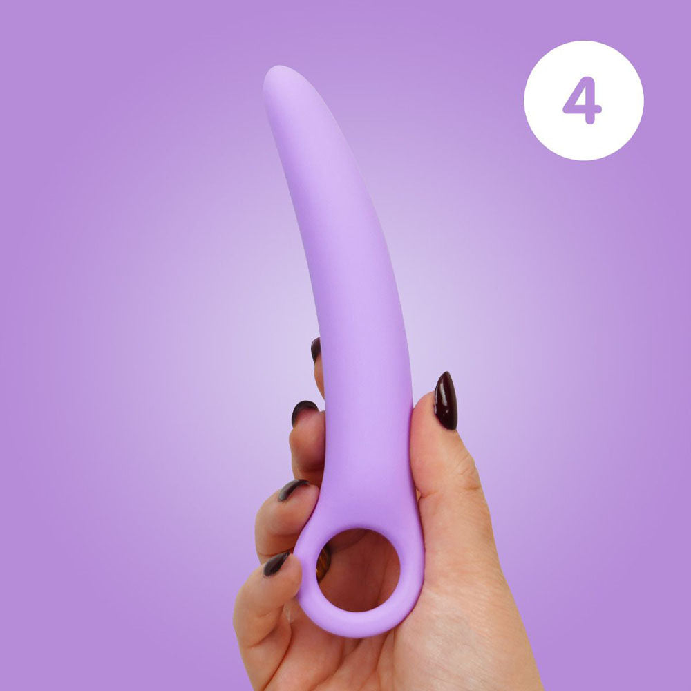 A hand holds a curved purple silicone dilator with a finger loop.