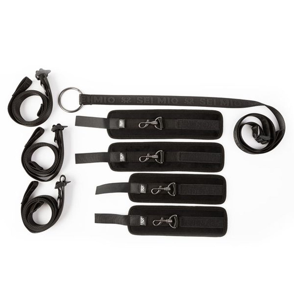 Black adjustable under mattress bed restraint system with padded cuffs.