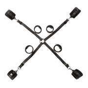 Black adjustable bed restraint system with four padded cuffs and a central ring.