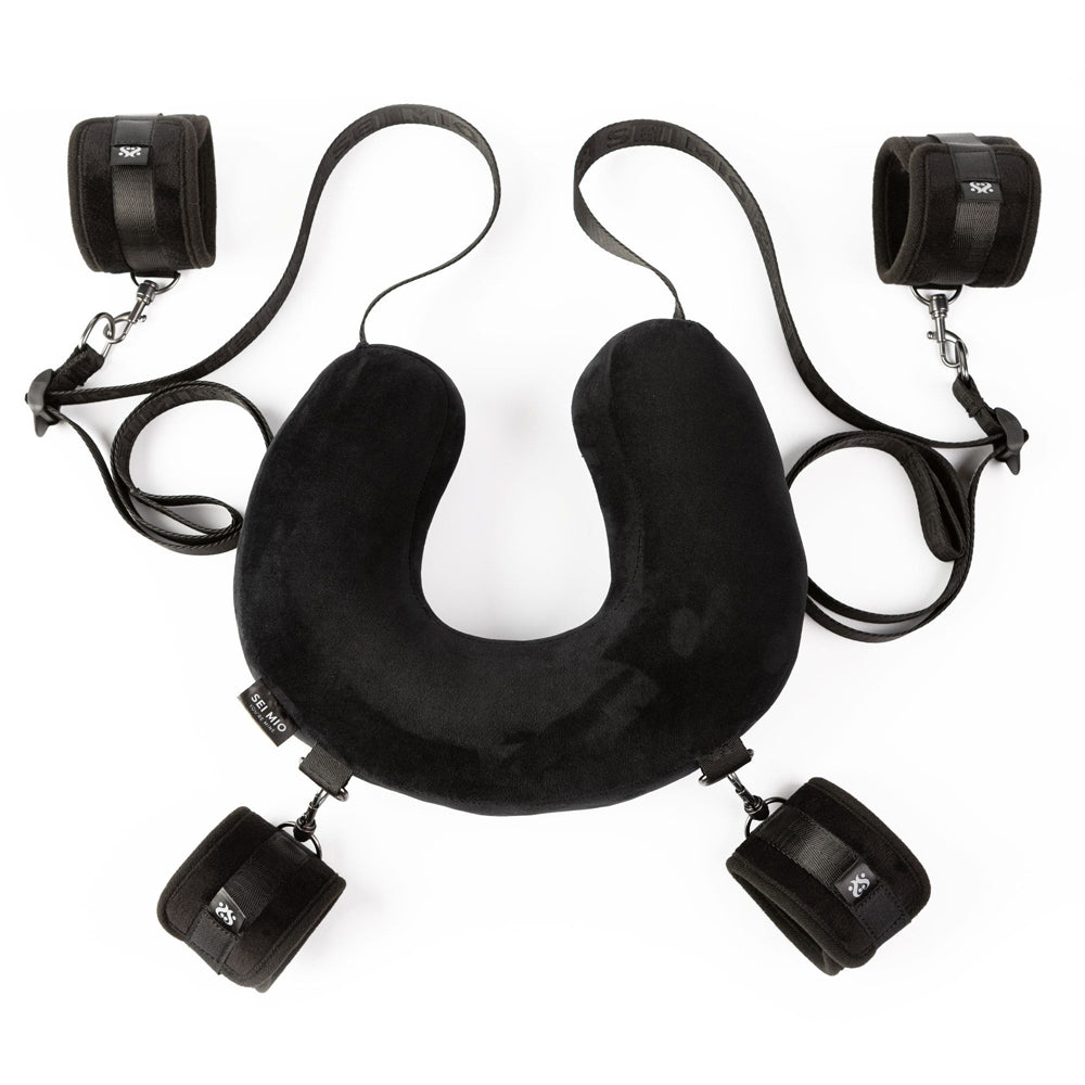 Black padded neck pillow with four wrist cuffs and straps.