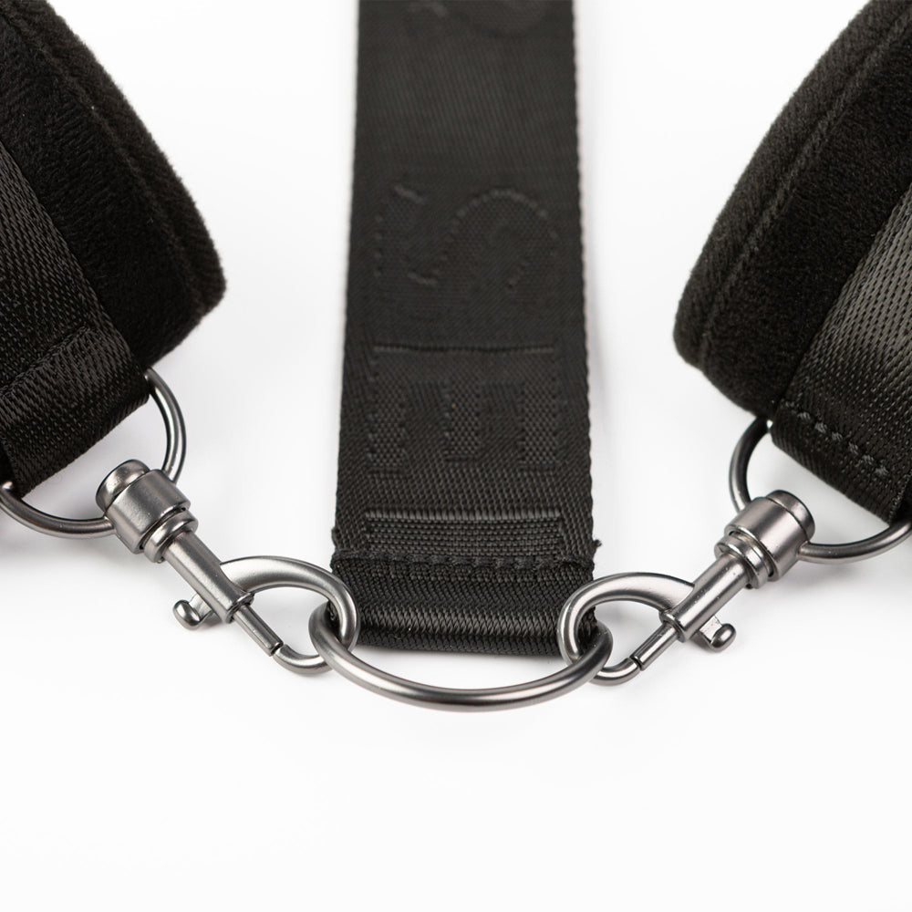 Black padded cuffs and strap with metal clasps.