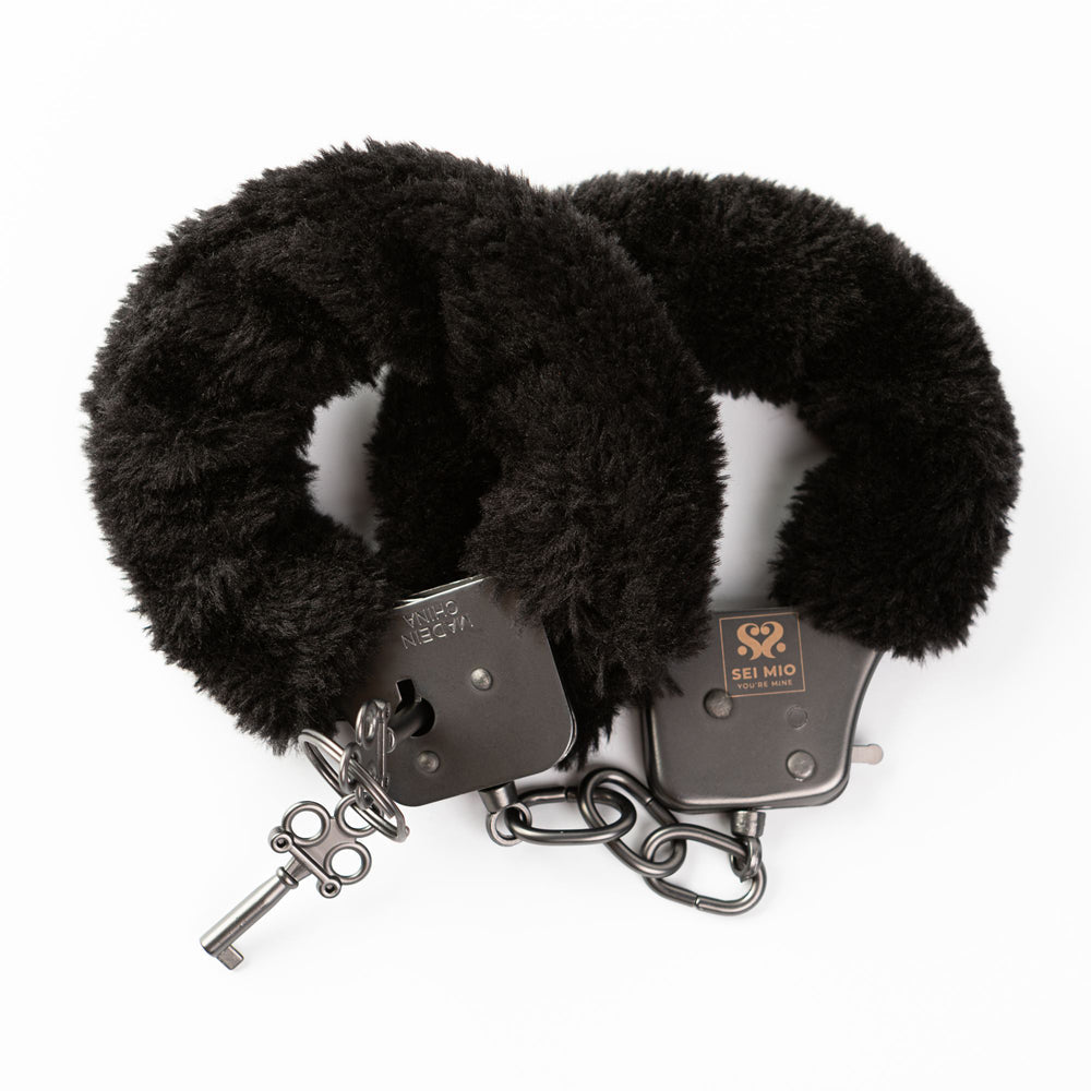 Black furry metal handcuffs with a key.