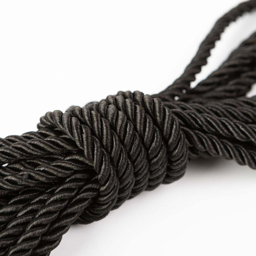 A close-up of a thick, black, silky rope tied in a knot.