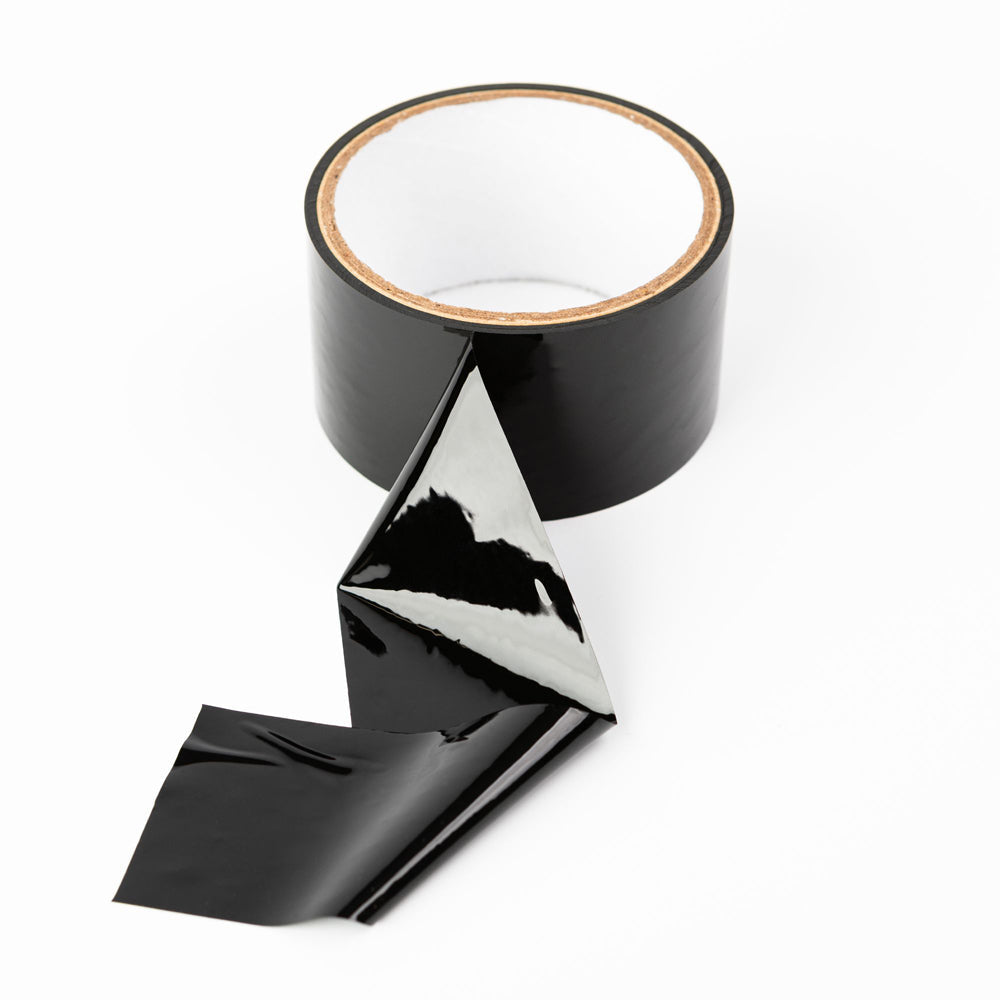 A roll of black, glossy self-adhering bondage tape with a portion unrolled.
