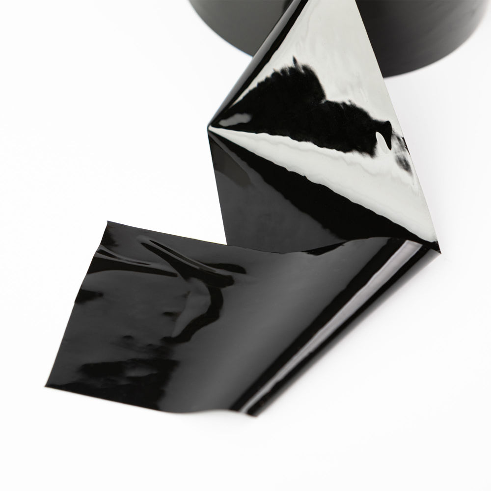 Black, glossy, self-adhering bondage tape on a white background.