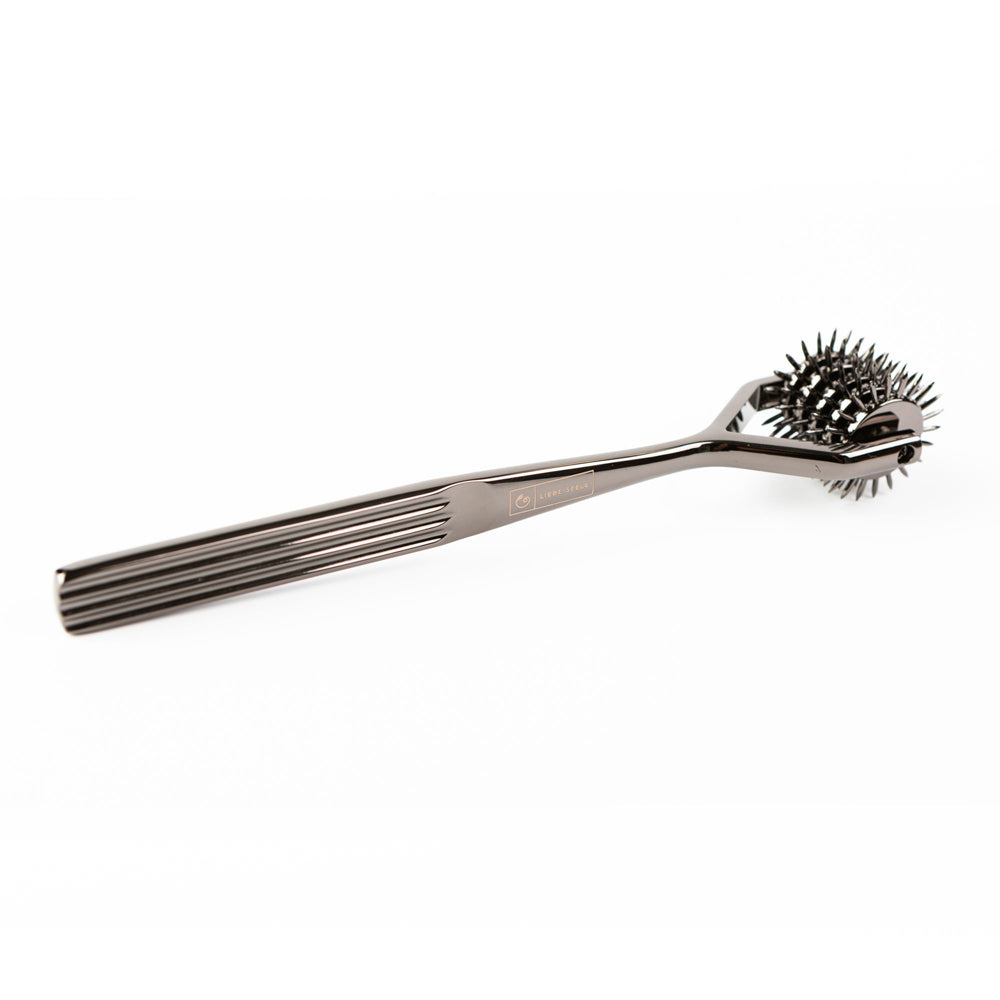 A metallic sensory pinwheel with five rows of spikes and a ribbed handle.