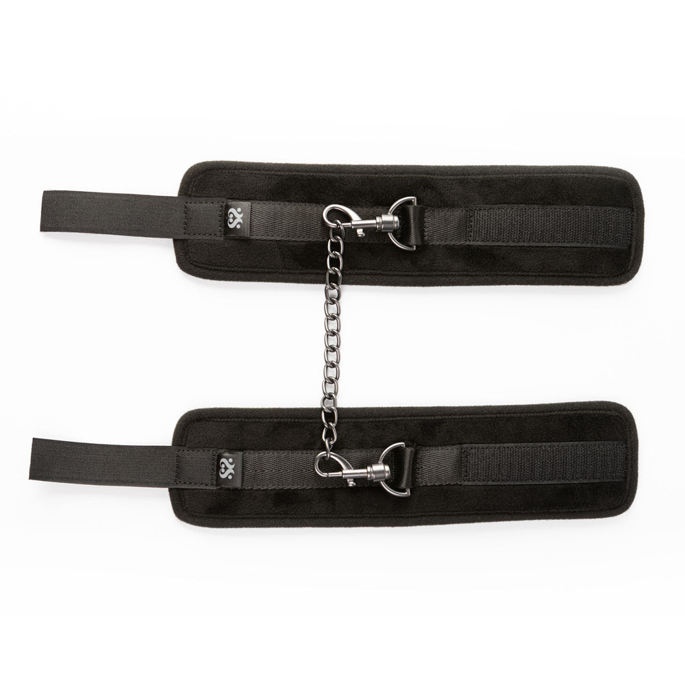 Black padded ankle restraints with adjustable velcro and a metal chain.