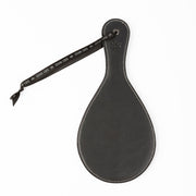 Black faux leather round spanking paddle with a black ribbon and white stitching.
