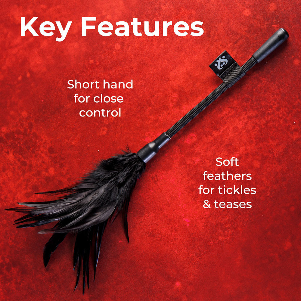 A black feather tickler with a short handle and a logo tag.