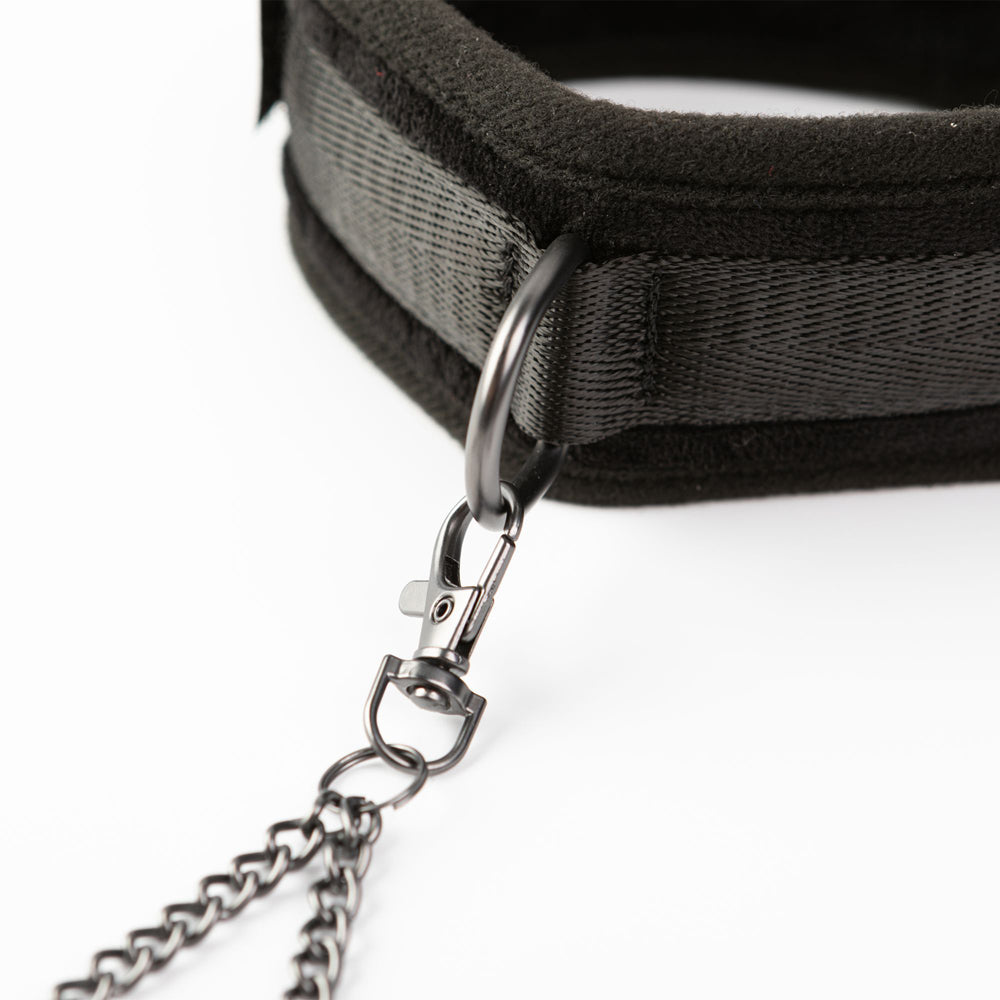 Black padded collar with a metal ring and chain attachment.