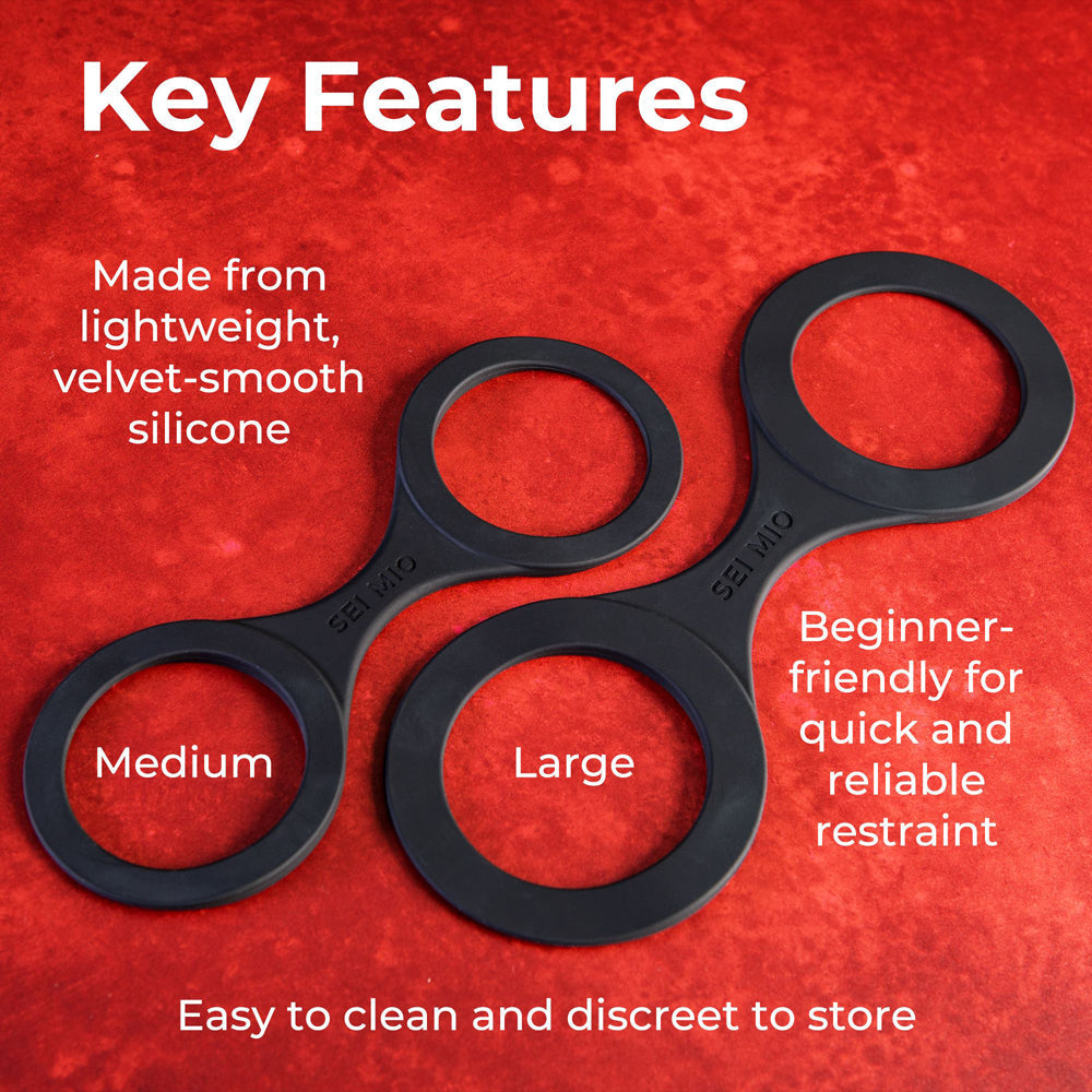 Two black silicone restraints, labeled "Medium" and "Large", on a red background.