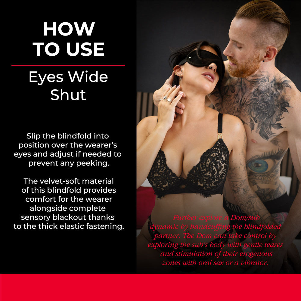A black velvet blindfold is worn by a woman as a man touches her face.