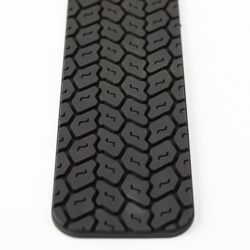 Black silicone spanking paddle with a tire tread texture.