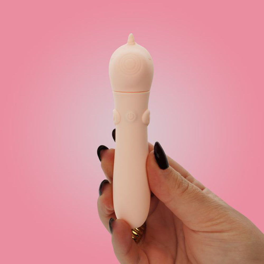 A hand holds a pink silicone bullet vibrator with a heart-shaped tip and control buttons.