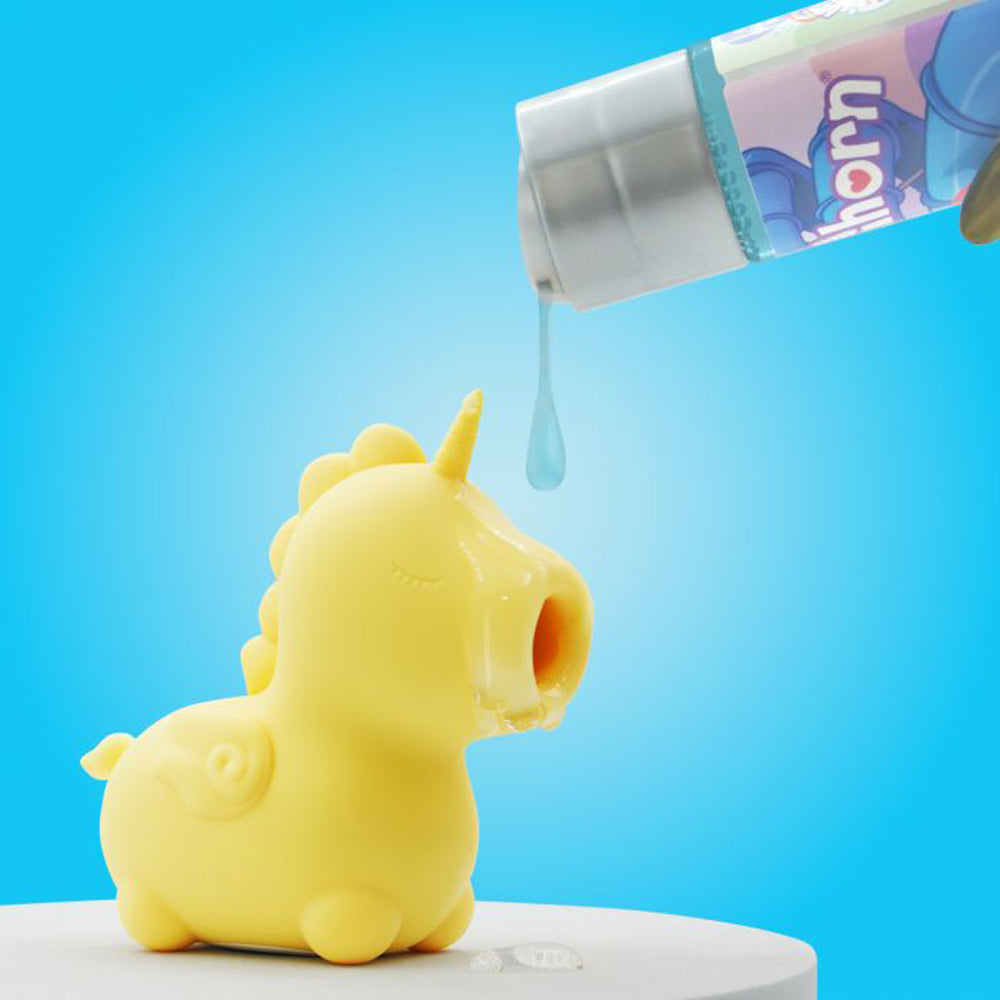 Yellow unicorn toy with liquid being dispensed from a tube.