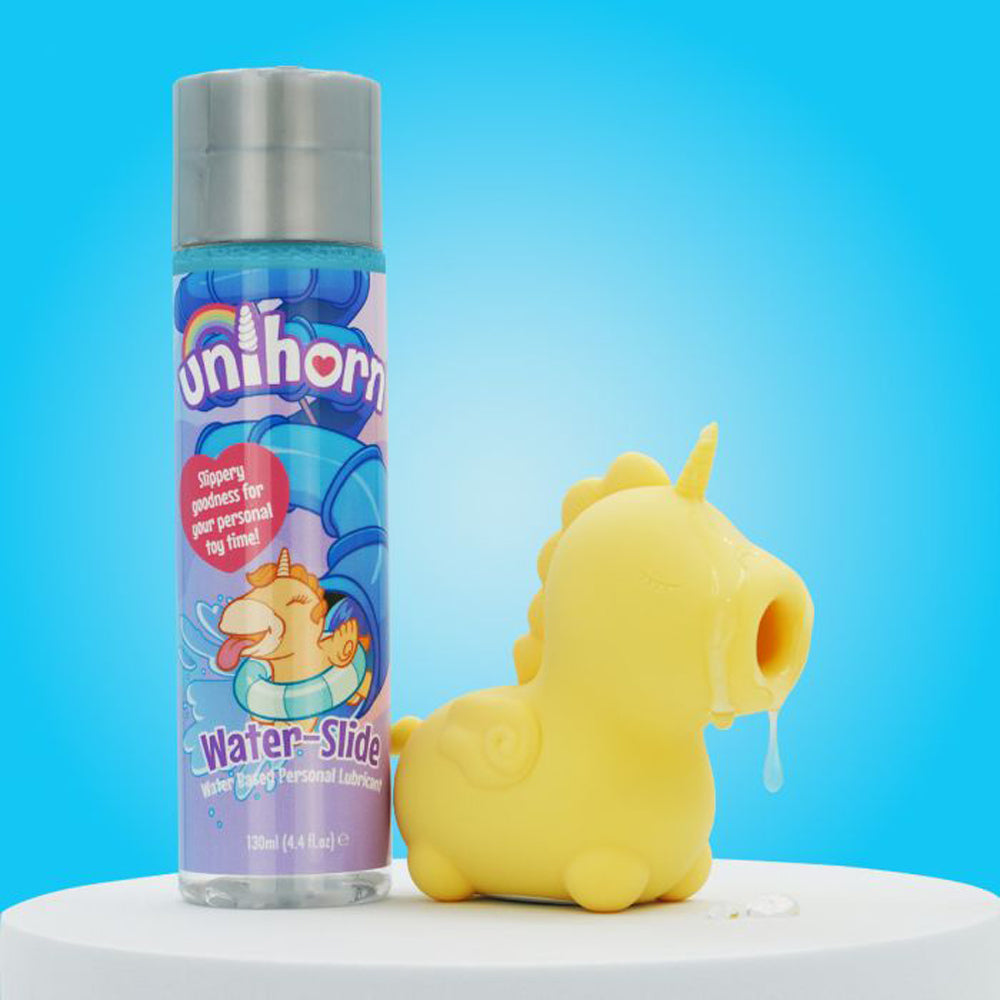 A bottle of Unihorn water-based lubricant next to a yellow unicorn-shaped toy.