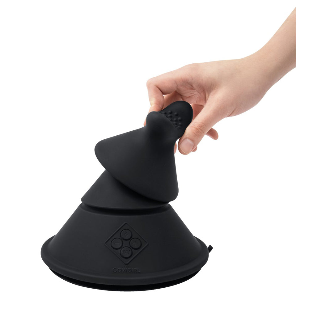A black silicone Cowgirl Cone sex machine held by a hand.