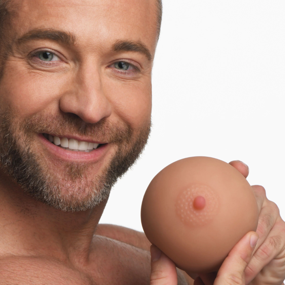 Man holding a realistic breast-shaped masturbator with a nipple.